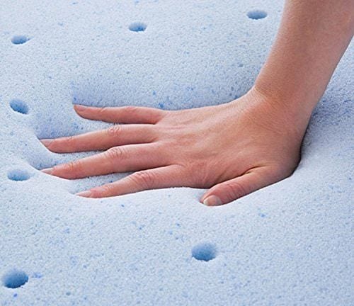 Gel pad memory foam that's blue with a hand pressing on it that's got aeration through it