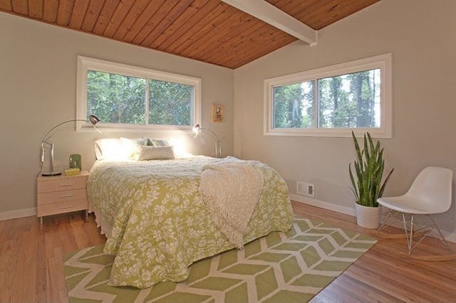 Phòng ngủ màu xanh lá cây với thiết kế trần nhà lộ dầm