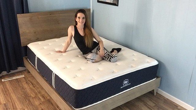 Female sitting in the middle of Brooklyn Bedding mattress