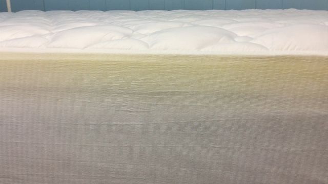 Eluxury side shot of a mattress with the topper on it