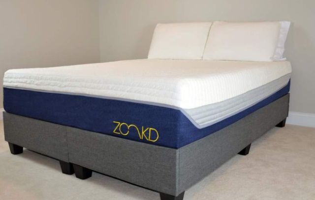 Zonkd mattress that's in a white room and has white sheets on it.