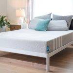 Leesa mattress on a bed frame in a staged well lit room with hardwood