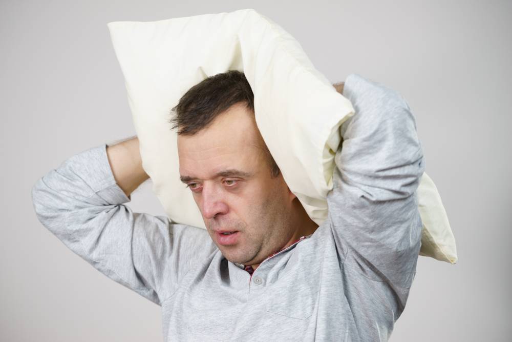 man resting pillow on back of his head