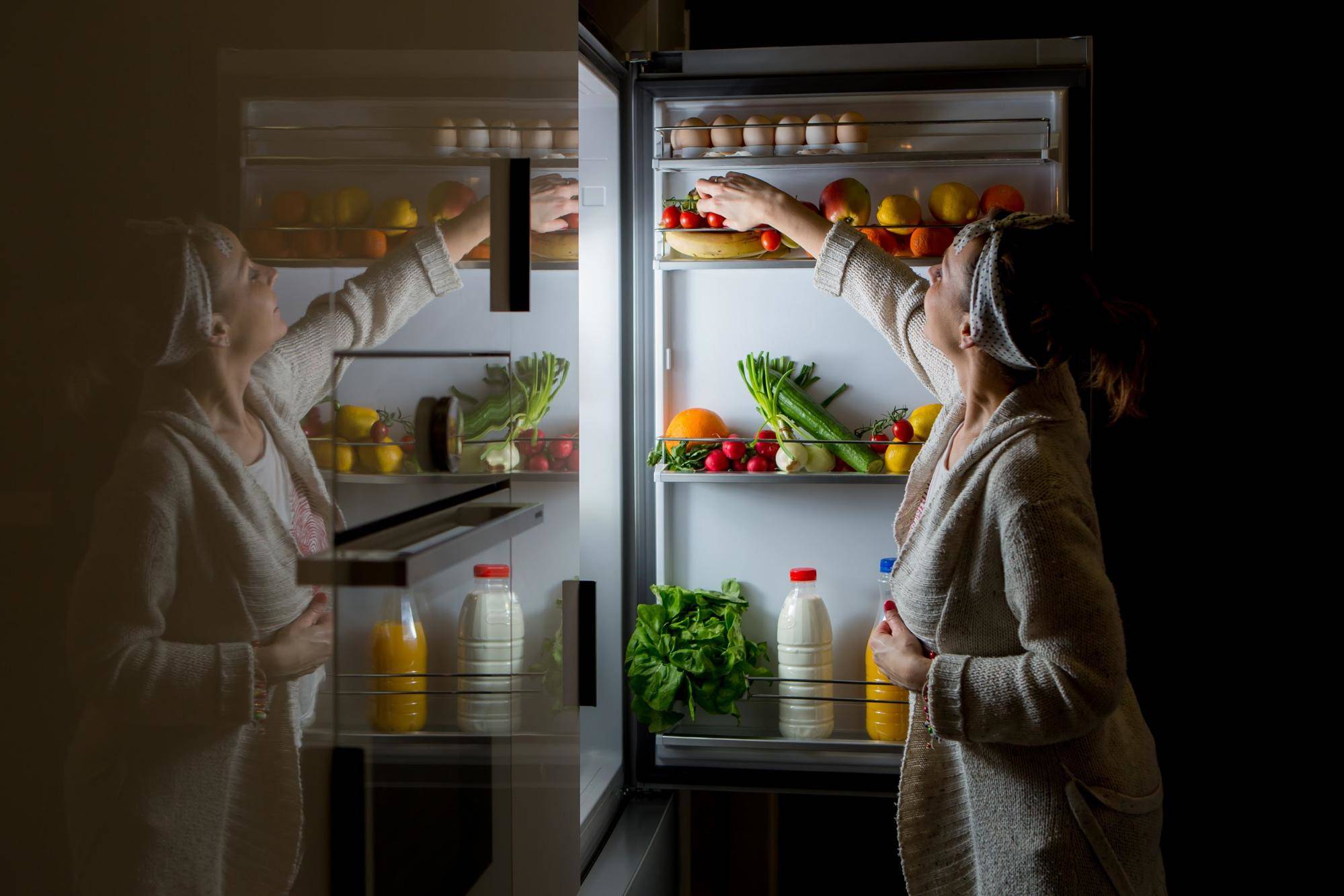 female reaching for food in the fridge